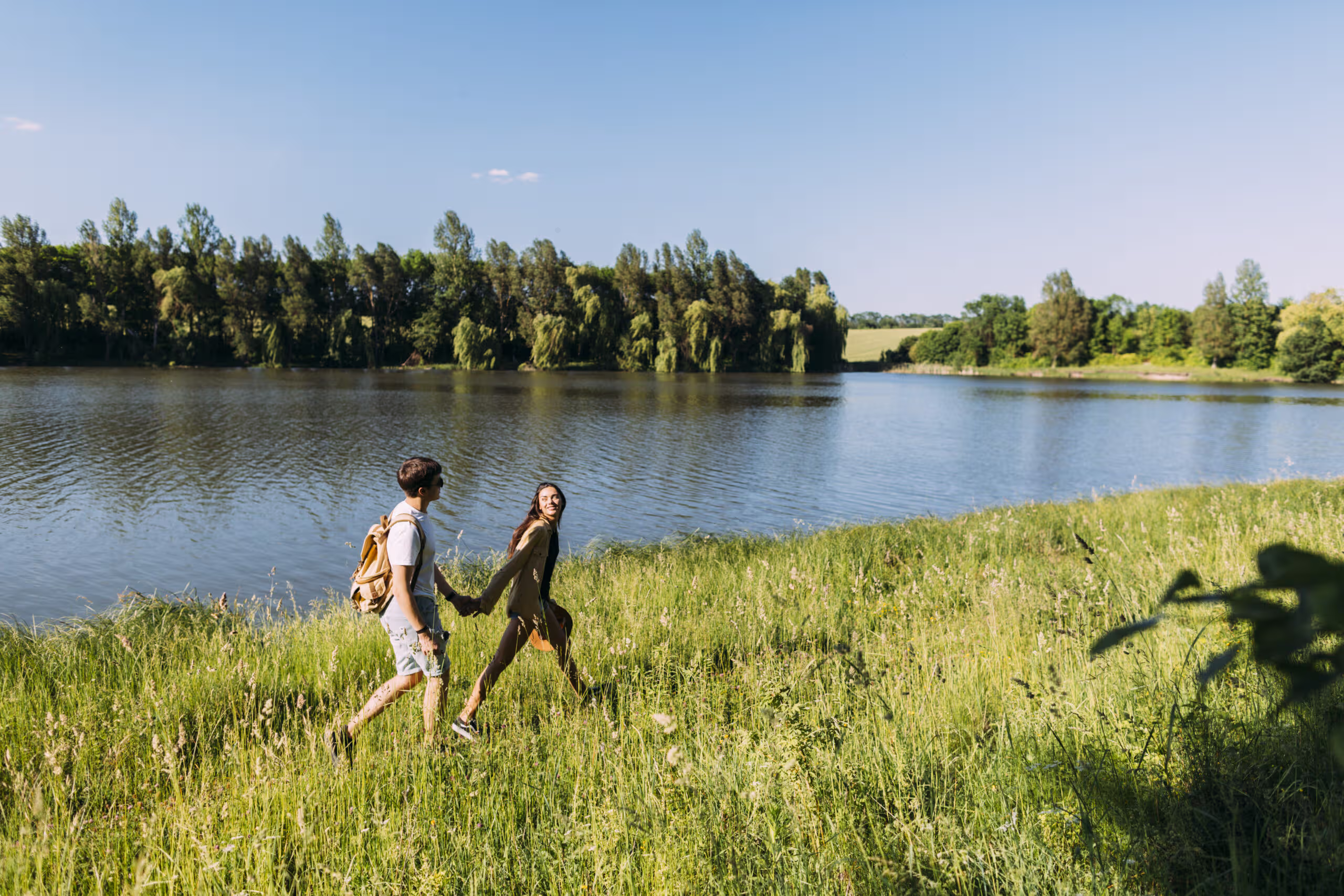 Zalew Poraj 9 happy couple walking green grass near idyllic lake scaled